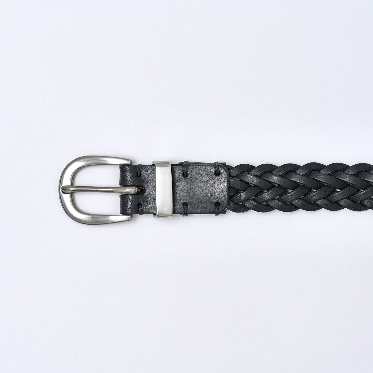 Black braided belt with silver buckle on a light gray background