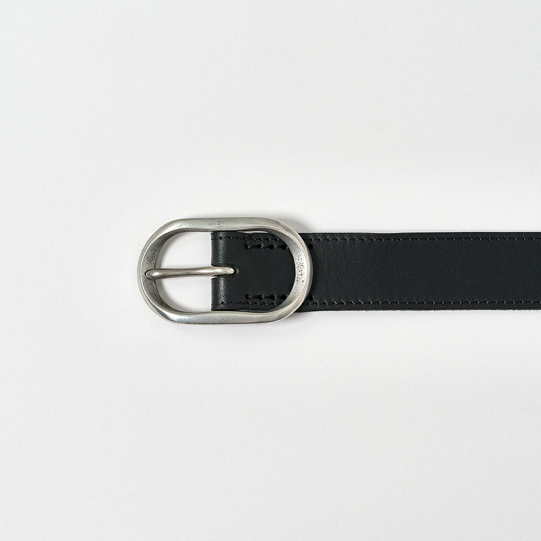 Black belt with silver buckle on a light gray background
