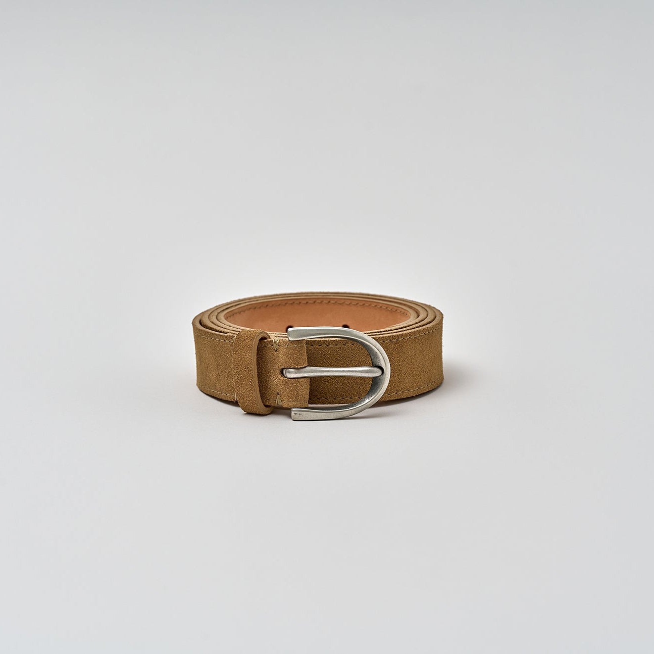 Brown belt with a silver buckle on a light gray background