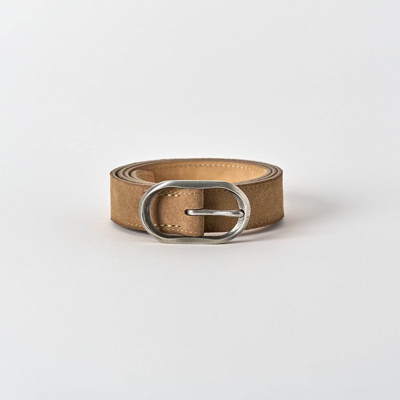 Brown leather belt with a silver buckle on a white background